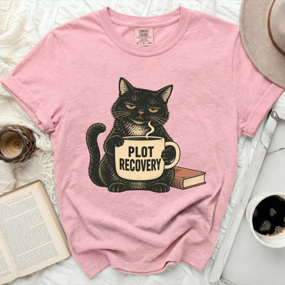 Pink t-shirt with black cat holding "PLOT RECOVERY" mug and a book.
