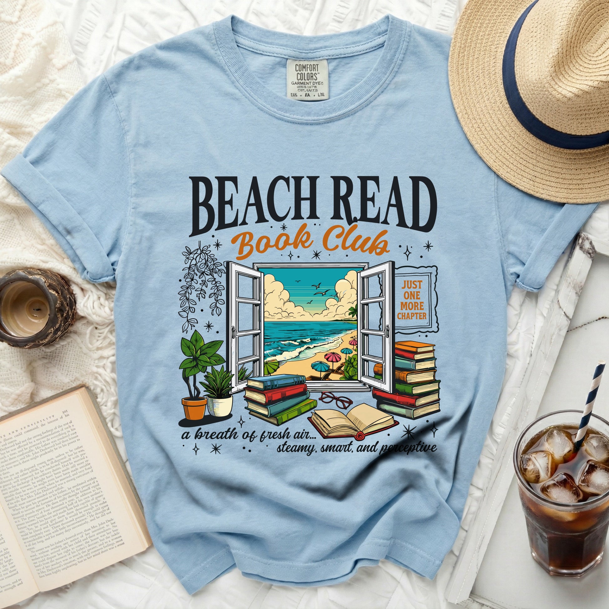 Light blue t-shirt with "Beach Read Book Club" graphic and beach scene in a window.
