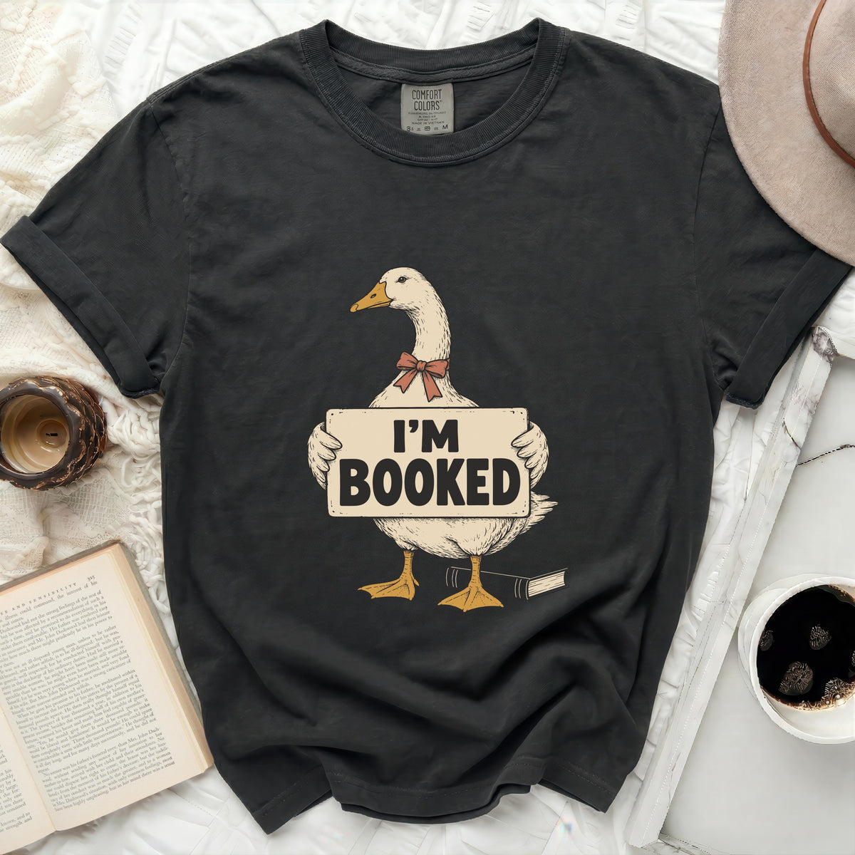 T-shirt with a duck graphic holding an "I'm Booked" sign and a book.