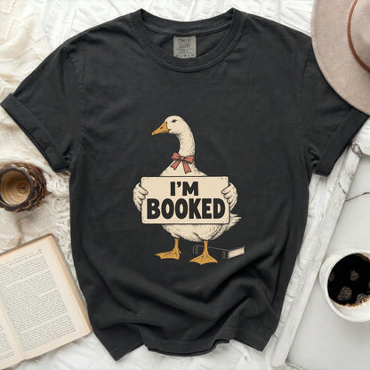 T-shirt with a duck graphic holding an "I'm Booked" sign and a book.