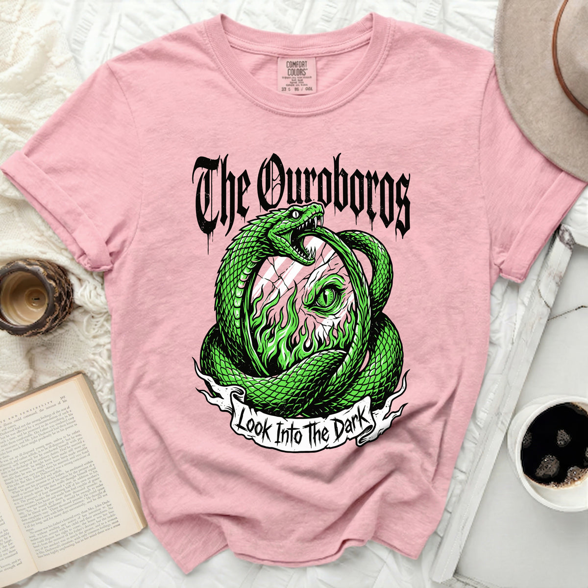 Pink t-shirt with green snake design and text "The Ouroboros Look Into The Dark".