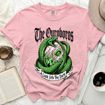 Pink t-shirt with green snake design and text "The Ouroboros Look Into The Dark".