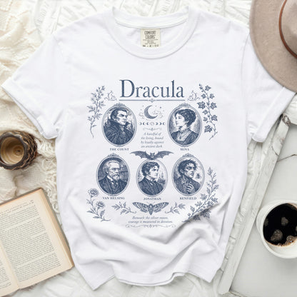 White T-shirt with blue "Dracula" print featuring characters, moon phases, bat, and moths.