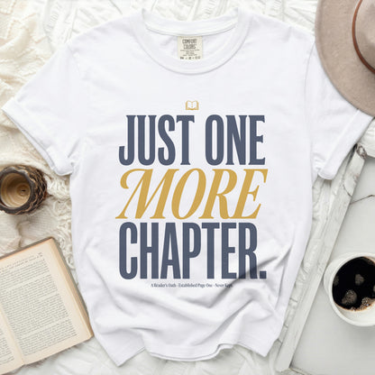 White t-shirt with "JUST ONE MORE CHAPTER." text and an open book graphic.