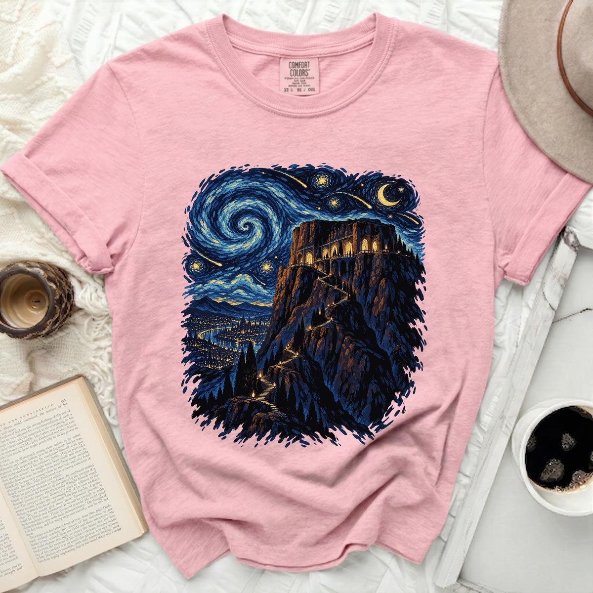 Pink t-shirt with a dark starry night mountain castle graphic and Comfort Colors tag.