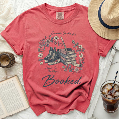 Coral t-shirt with bookish ice skates and hockey stick graphic.