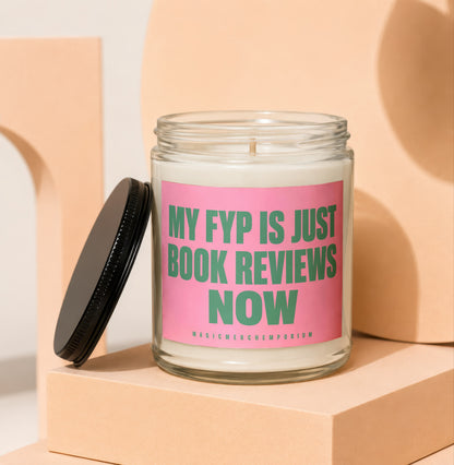 Glass candle with pink label that reads "MY FYP IS JUST BOOK REVIEWS NOW" and smaller text "MAGICMERCH...EMPORIUM".