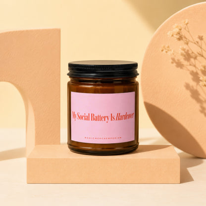 Brown glass candle with pink label reading "My Social Battery Is Hardcover".