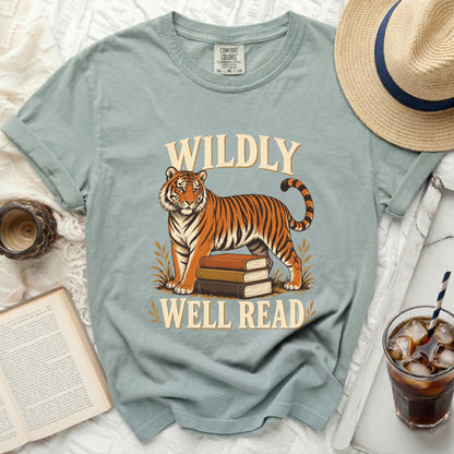 Light blue t-shirt with tiger and books graphic, text reads "WILDLY WELL READ".