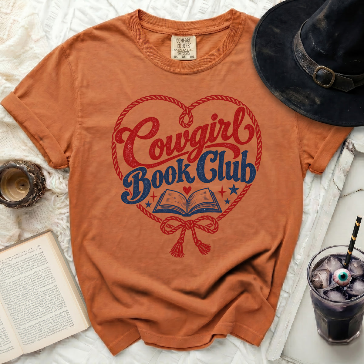Orange t-shirt with "Cowgirl Book Club" graphic inside a heart shape.