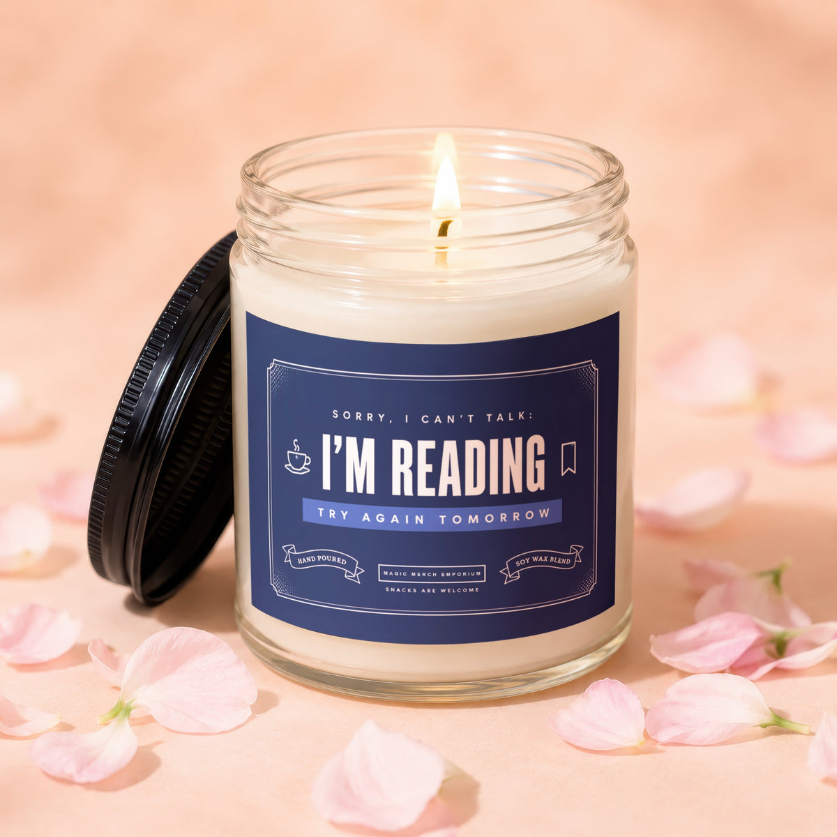 Glass candle with "I'm Reading" label and lit flame, surrounded by petals.