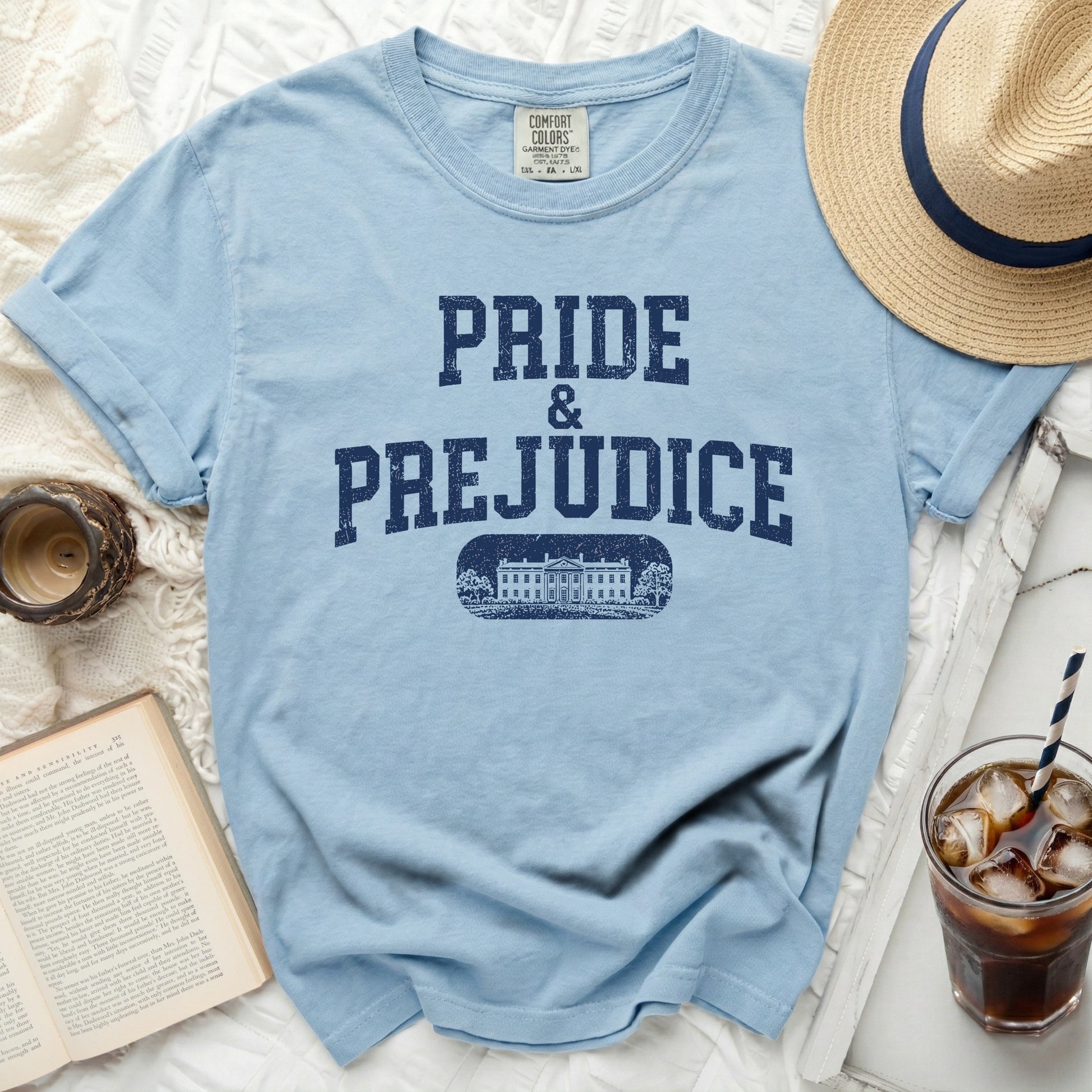 Light blue t-shirt with "Pride & Prejudice" text and stately home graphic.