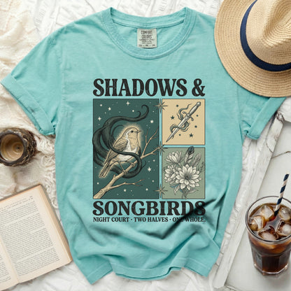 Teal t-shirt with "Shadows & Songbirds" graphic of a bird and dagger.