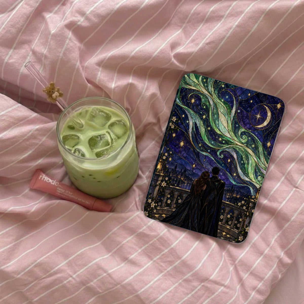 Phone case with couple under starry aurora borealis sky beside matcha drink.