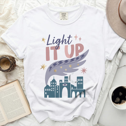 White Comfort Colors t-shirt with "Light IT UP" graphic and city design.