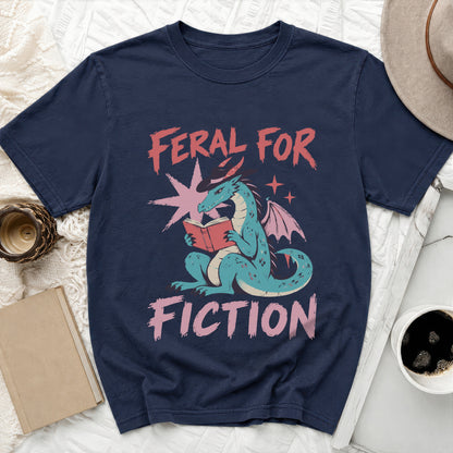 Navy t-shirt with a blue dragon reading a book, text "FERAL FOR FICTION".