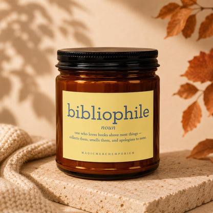 Amber candle with "bibliophile noun" definition label and "MAGICMERCHEMPORIUM" text.