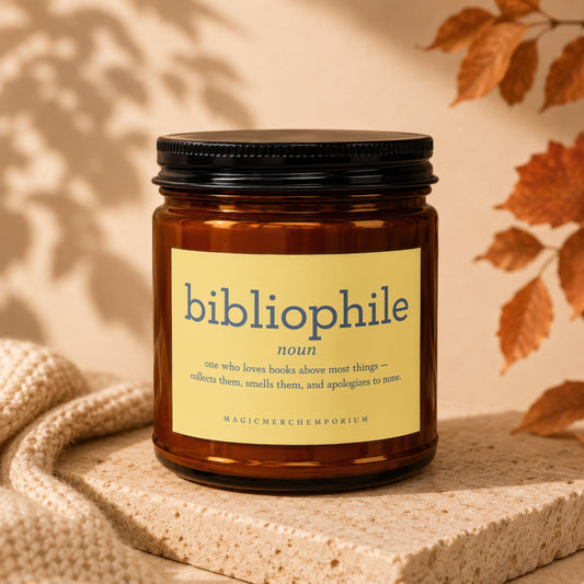 Amber candle with "bibliophile noun" definition label and "MAGICMERCHEMPORIUM" text.