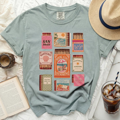 T-shirt with various retro-style book and travel-themed box graphics.