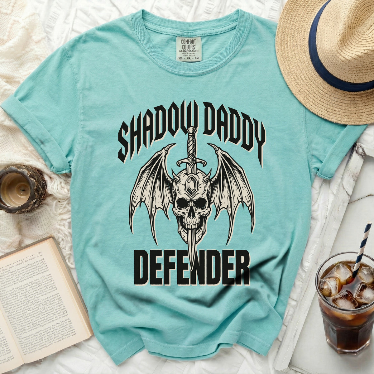 Teal t-shirt with skull, wings, sword, and "Shadow Daddy Defender" graphic.