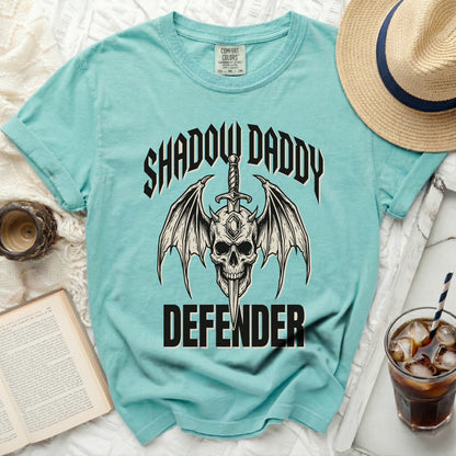 Teal t-shirt with skull, wings, sword, and "Shadow Daddy Defender" graphic.