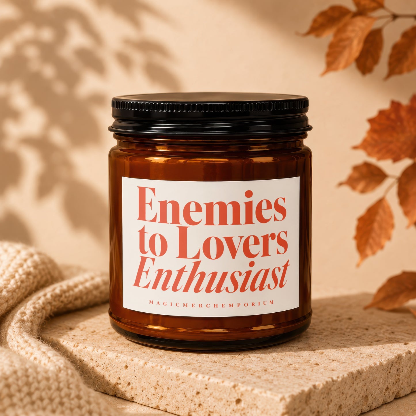 Amber candle with "Enemies to Lovers Enthusiast" text on label.