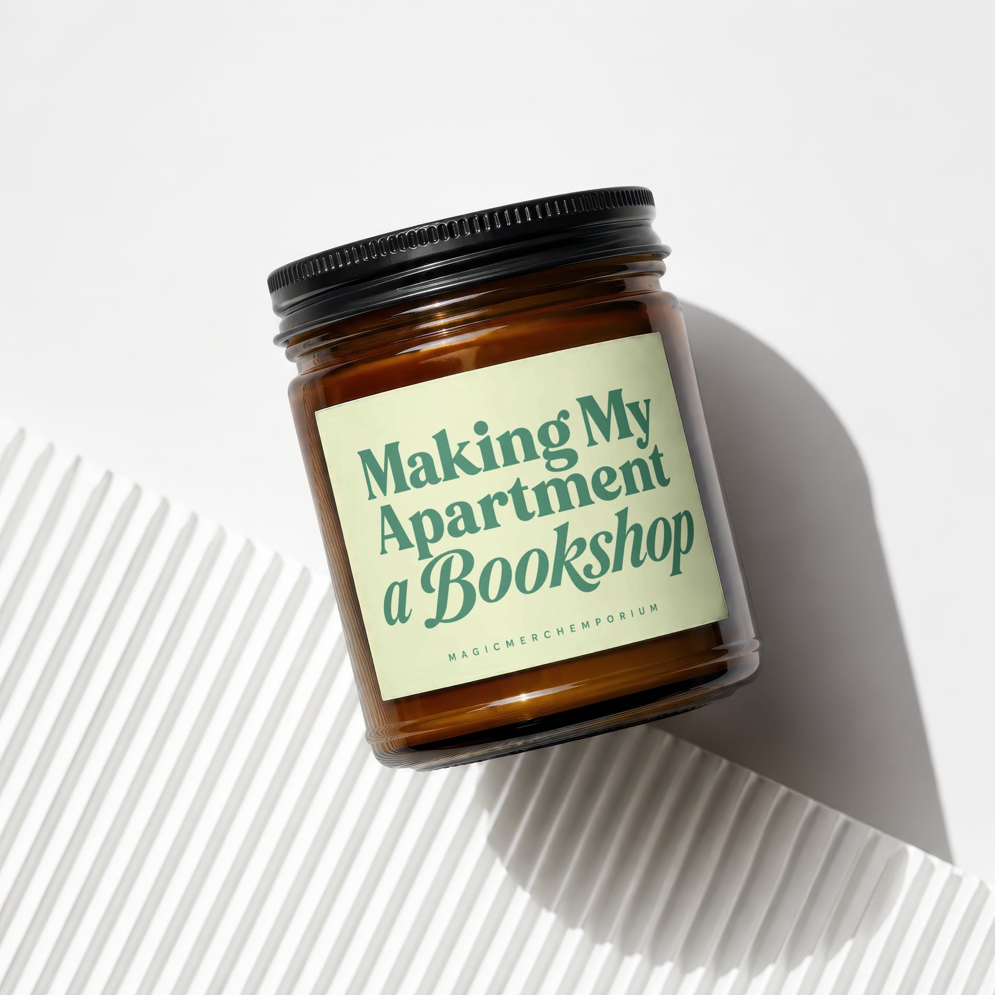 Amber glass candle with a light green label that reads "Making My Apartment a Bookshop."