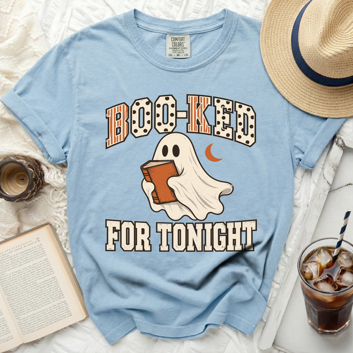 Ghost reading a book with text "Boo-ked For Tonight" on a light blue t-shirt.