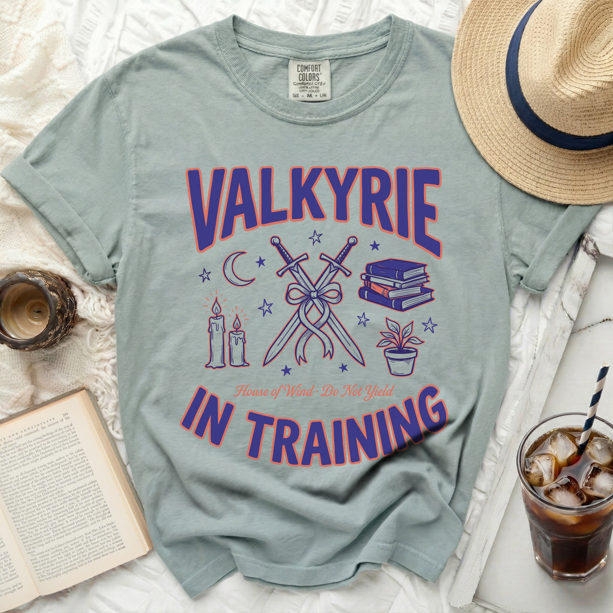 Light sage t-shirt with "VALKYRIE IN TRAINING" text, swords, books, and candles.