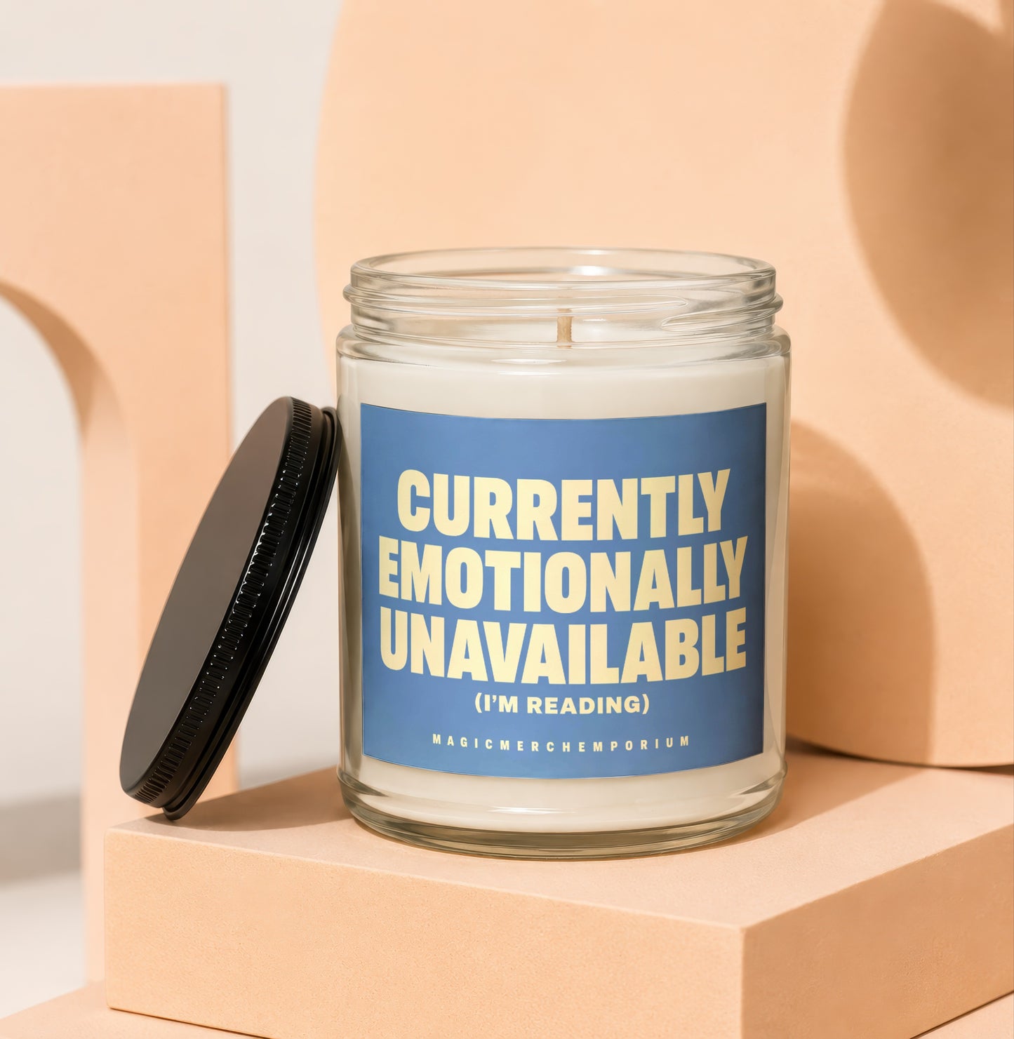Glass candle with blue label reading "Currently Emotionally Unavailable (I'm Reading)".