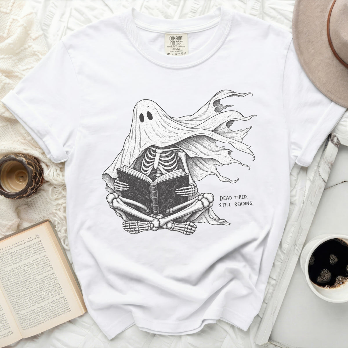 Skeleton ghost reading a book with text "DEAD TIRED. STILL READING."