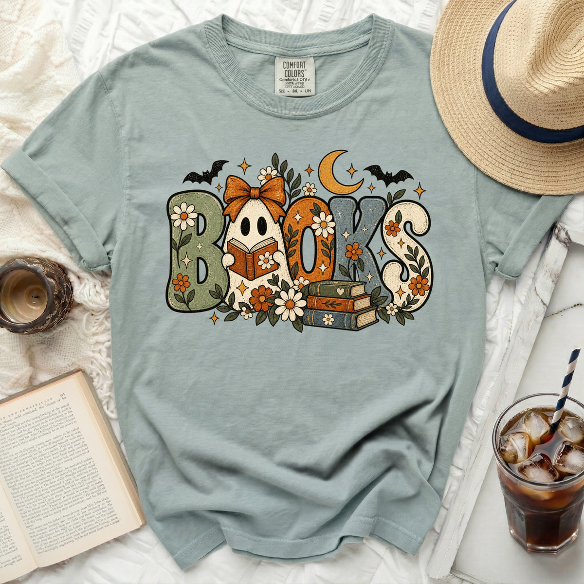 Ghost reading a book with "BOOKS" in retro font, surrounded by flowers and bats.