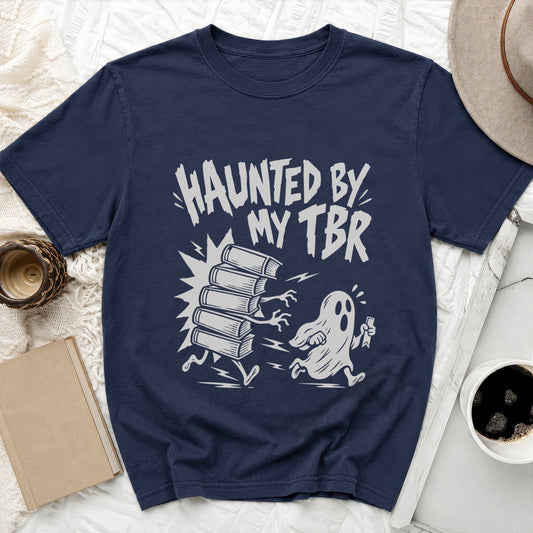 Navy t-shirt with "Haunted by My TBR" text and cartoon books chased by a ghost.