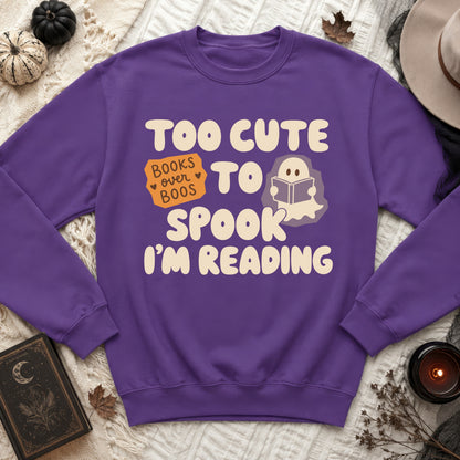 Purple sweatshirt with "Too cute to spook, books over boos, I'm reading" text.
