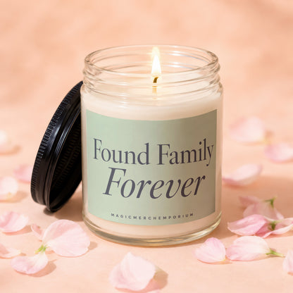 Glass candle with lit wick, label reads "Found Family Forever"
