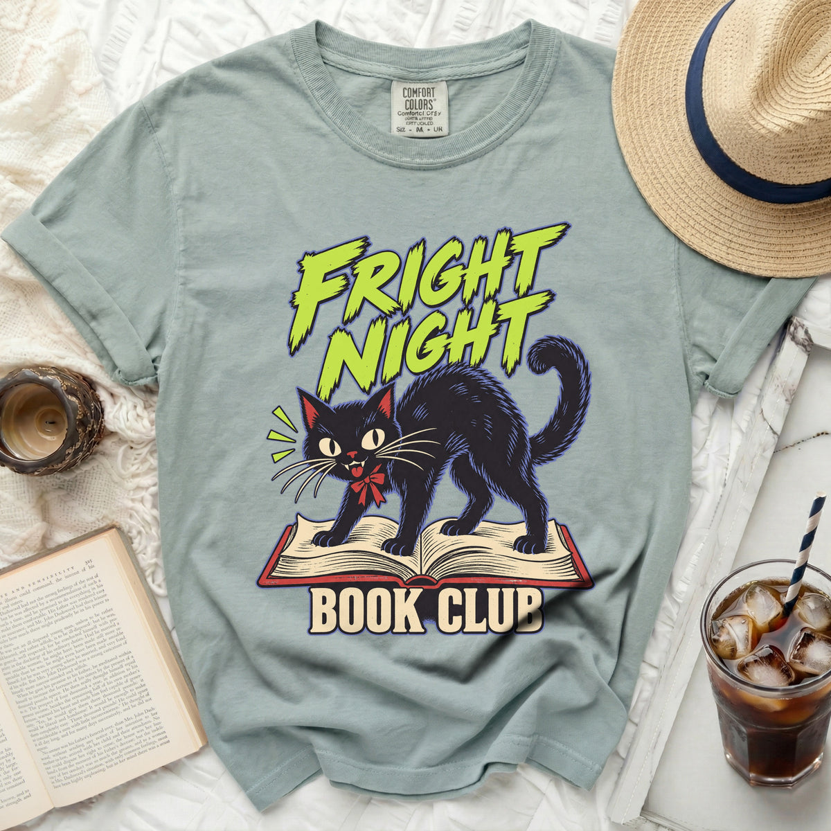 Fright Night Book Club graphic on a sage green t-shirt with a black cat.