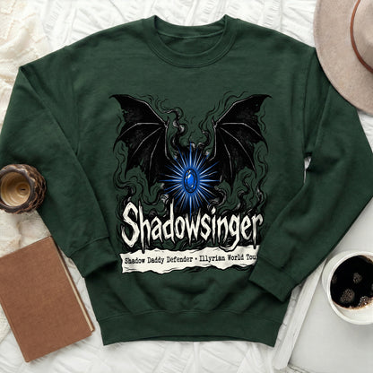 Dark green crewneck sweatshirt featuring a graphic with bat wings, a blue gem, and text reading "Shadowsinger."