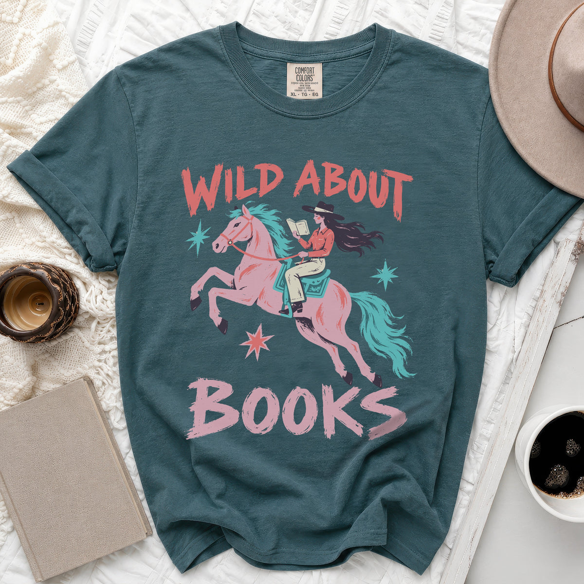 Teal t-shirt with "Wild About Books" graphic featuring a cowgirl reading on a pink horse.