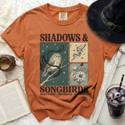 Orange t-shirt with "Shadows & Songbirds" graphic of a bird and dagger.