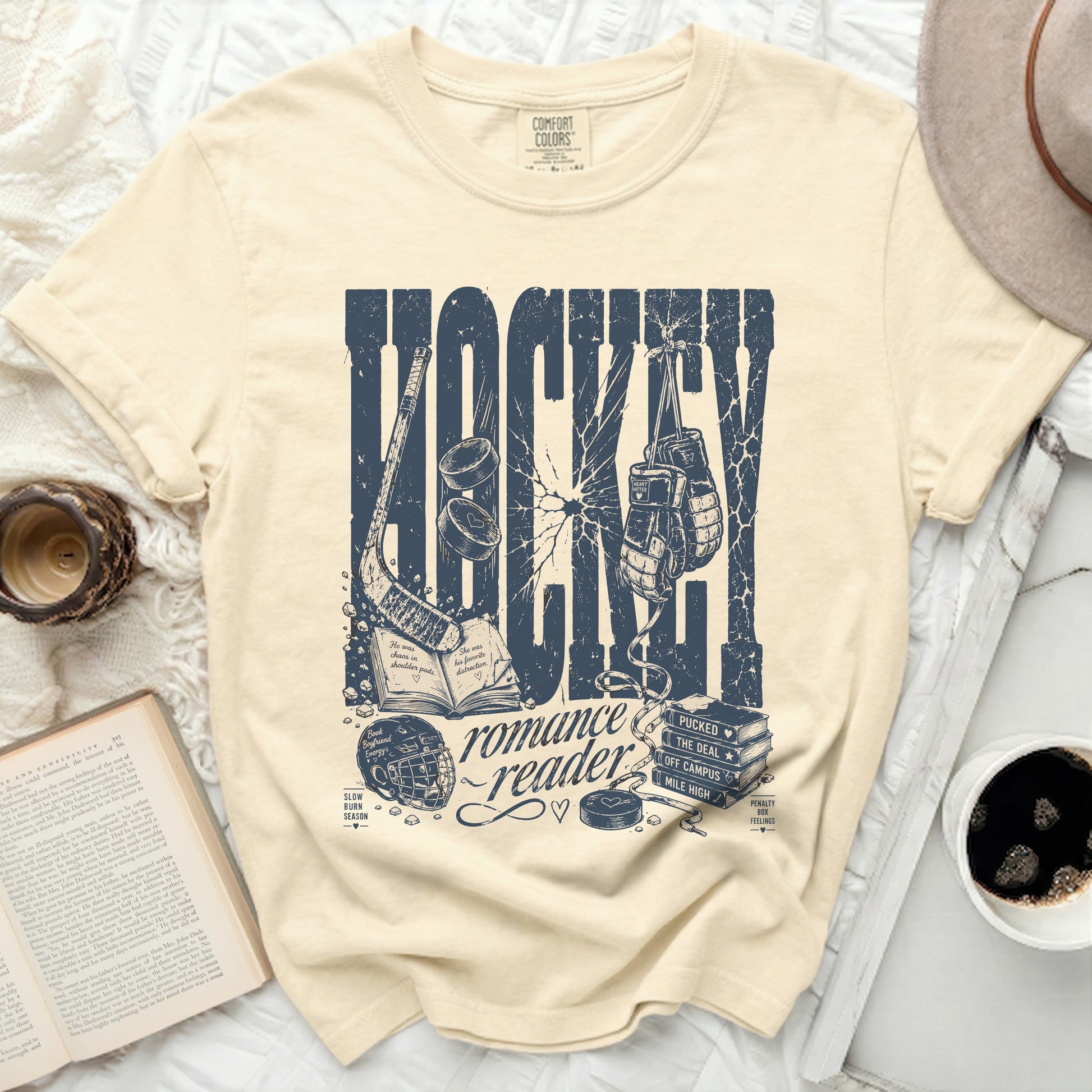 Cream t-shirt with "HOCKEY romance reader" graphic and hockey elements.