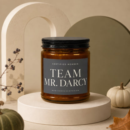 Amber candle with black lid reading "Certified Member: Team Mr. Darcy."