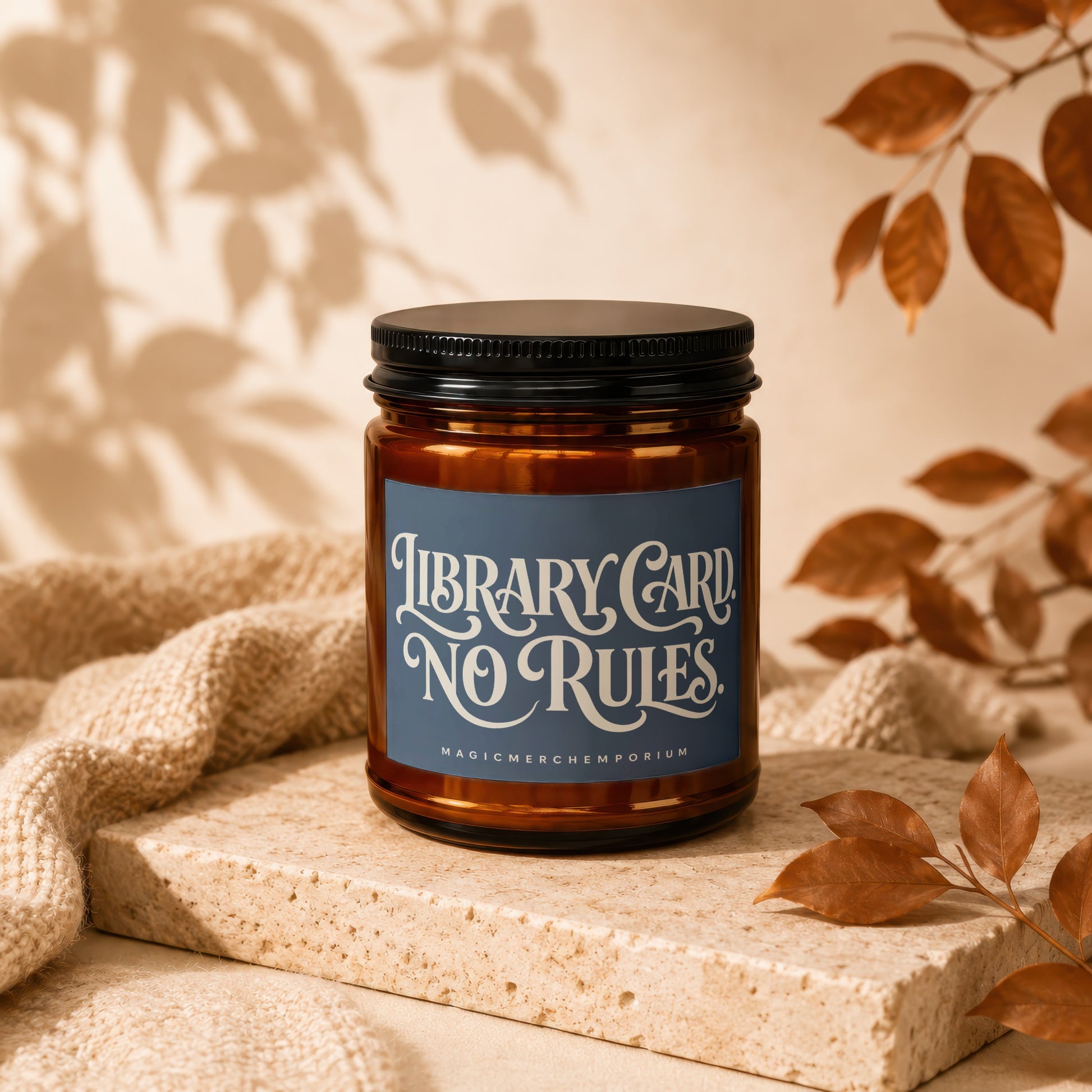 Amber jar candle with "Library Card, No Rules" text on blue label.