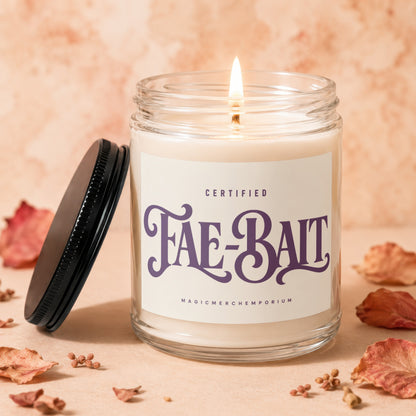 Jar candle with lit flame, "Fae-Bait" label, and dried foliage arrangement.