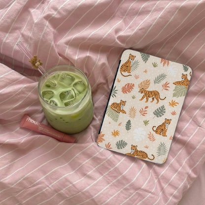 Journal with tiger and leaf pattern on pink striped background next to a matcha drink.