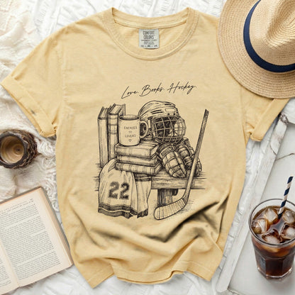 Yellow t-shirt with sketch of hockey gear, books, and text "Love. Books. Hockey."