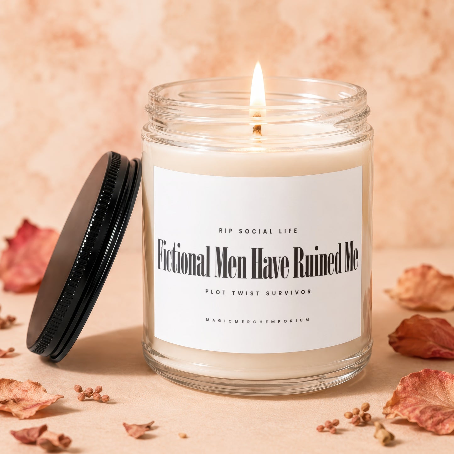 Glass candle with lit wick and black lid, reads "Fictional Men Have Ruined Me."