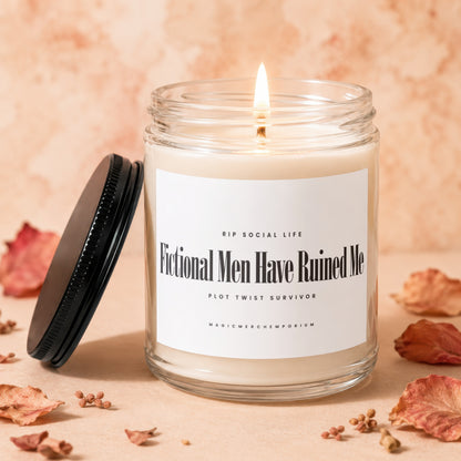 Glass candle with lit wick and black lid, reads "Fictional Men Have Ruined Me."