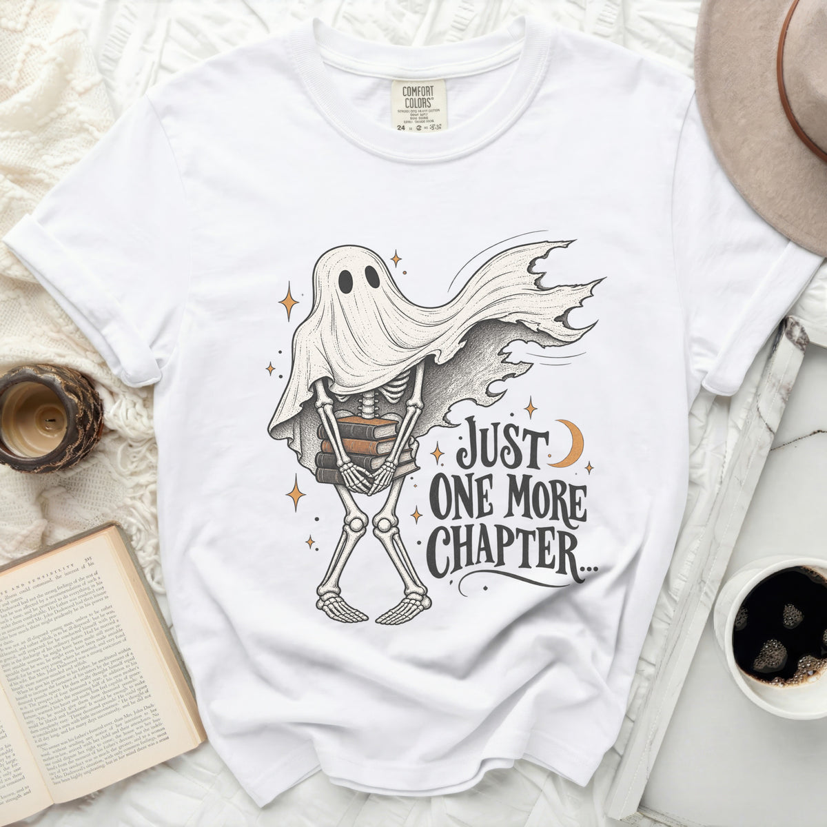 White t-shirt with skeleton ghost holding books and text "Just One More Chapter..."