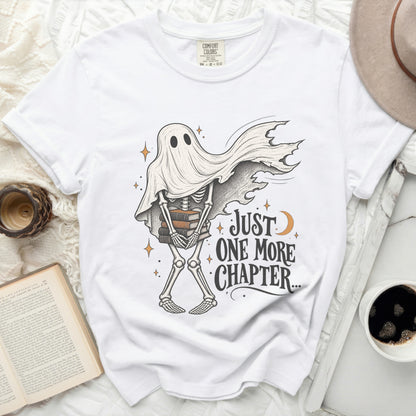 White t-shirt with skeleton ghost holding books and text "Just One More Chapter..."