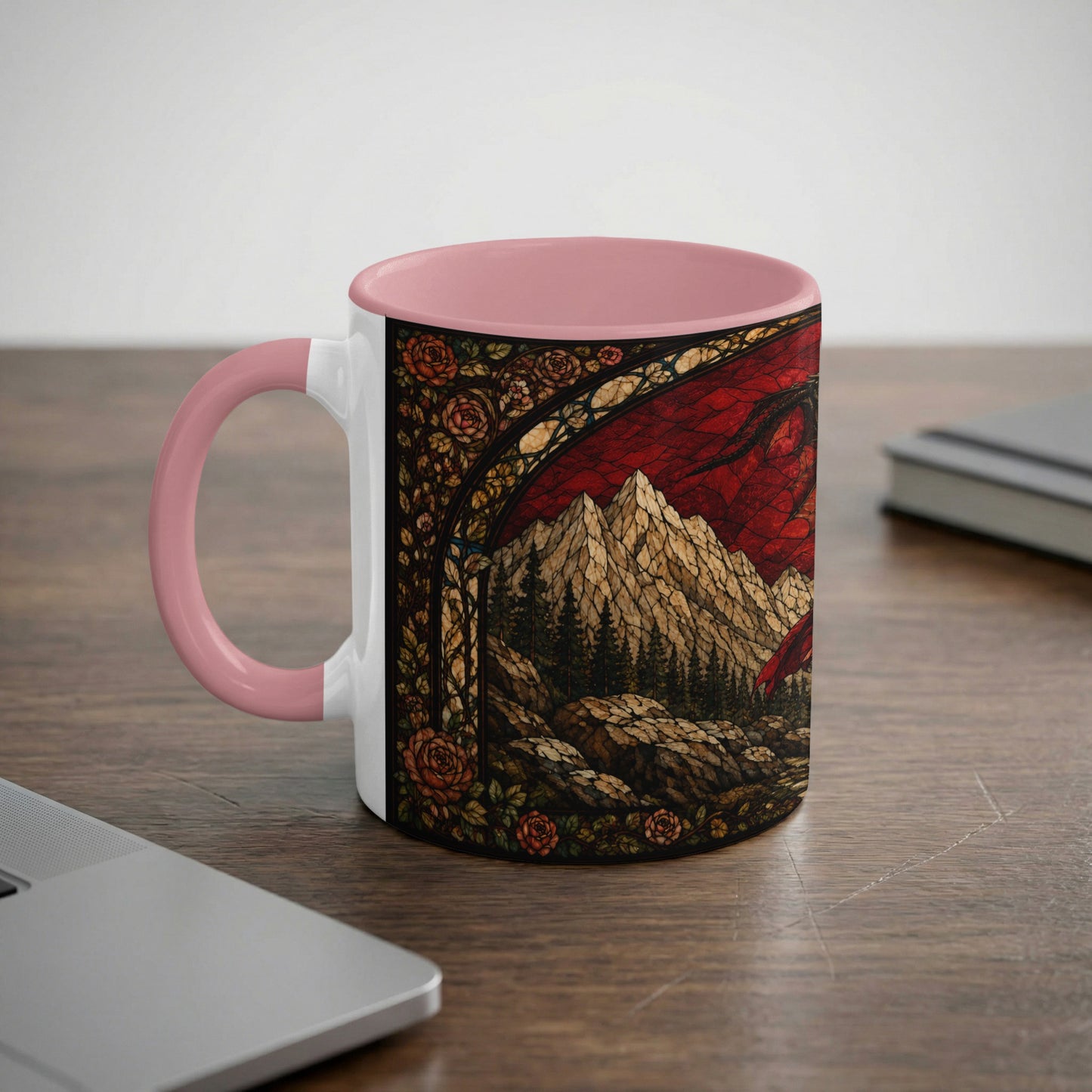 White mug with pink handle featuring a stained-glass design of a dragon and mountains.